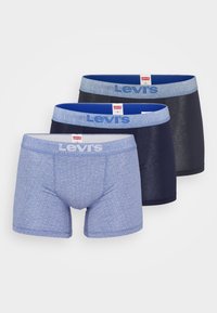 Tri parovi Levi's bokserica: jedan svijetloplavi s uzorkom, jedan tamnoplavi i jedan tamno plavi, svi s kontrastnim pojasovima.