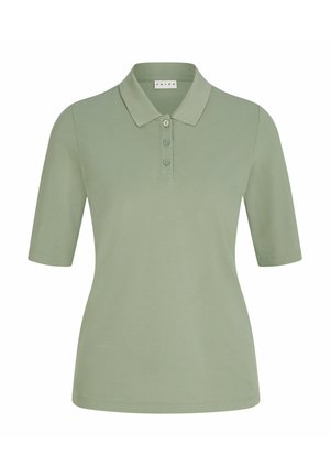 Olivgrünes Polohemd mit Kragen und drei Knöpfen, kombiniert mit hellbeigen weit geschnittenen Hosen. Weiße Sneakers runden das Outfit ab.