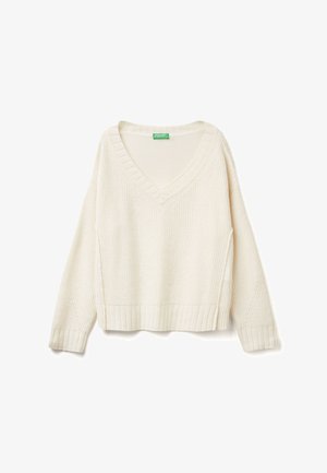 Strickpullover in cropped Form in Creme. Verfügt über einen V-Ausschnitt, gerippte Bündchen und Saum. Strukturiertes Muster im gesamten Design, mit seitlichen Schlitzen für mehr Bewegungsfreiheit.
