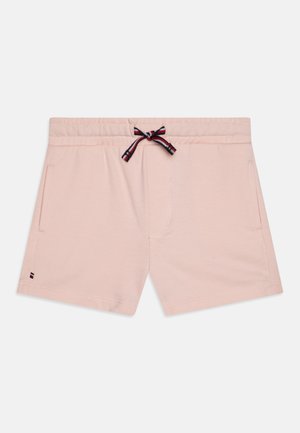 Pantalones cortos rosa claro con cinturilla elástica, dos bolsillos laterales y un cordón a rayas en negro, blanco y rojo atado con un lazo en la parte delantera.