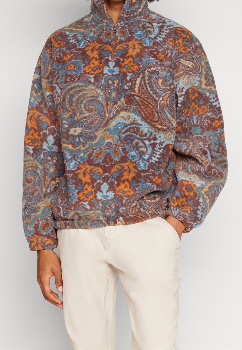 Pullover in pile con motivo paisley marrone, blu e arancione; colletto alto con zip; polsini elasticizzati; vestibilità rilassata.
