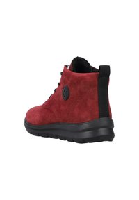 Bottines en suède rouge avec semelles en caoutchouc noir, bout arrondi, design à lacets et une languette à l'arrière pour un enfilage facile.