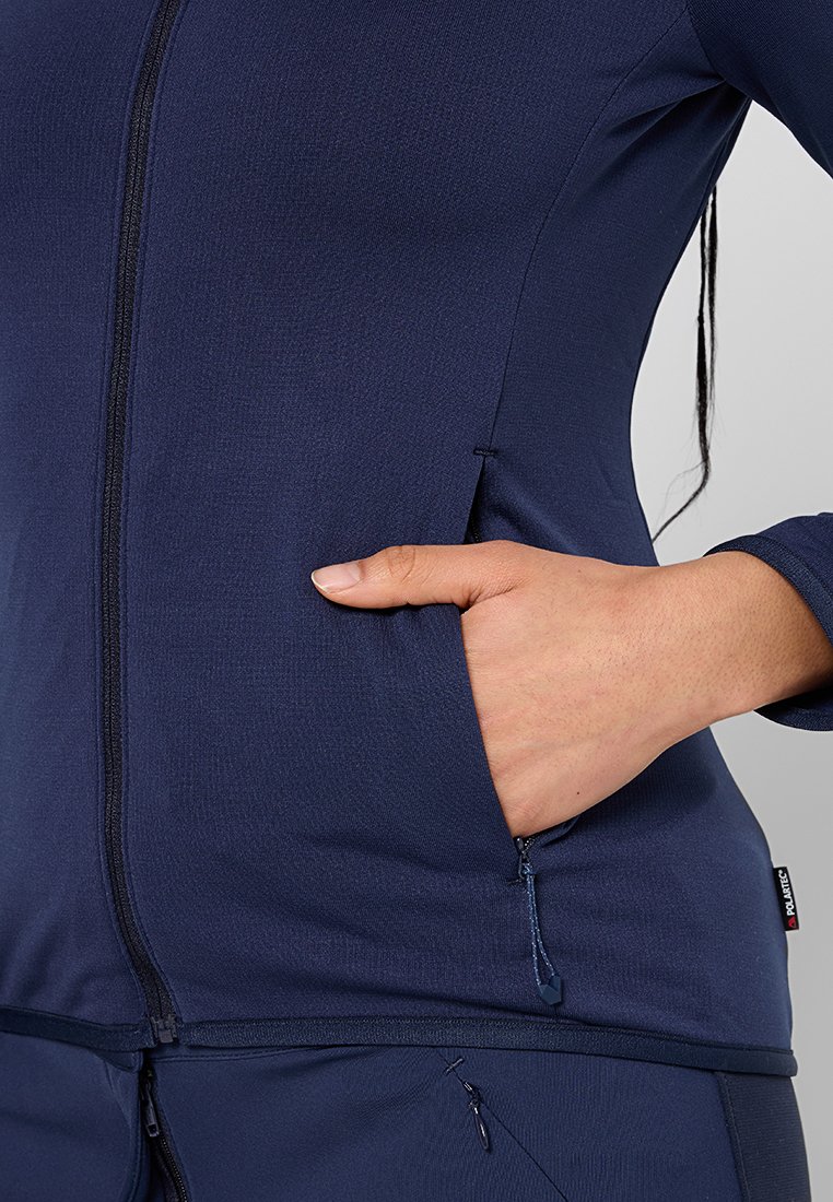 Giacca leggera blu navy con zip, dotata di tasche laterali e tessuto testurizzato. Presenta un design aderente e dettagli di cucitura sottili.