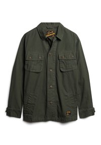 Groene utilityjack van lichtgewicht stof. Beschikt over twee borstzakken met knoopflappen en een logopatch aan de onderkant. Knoopsluiting aan de voorkant.