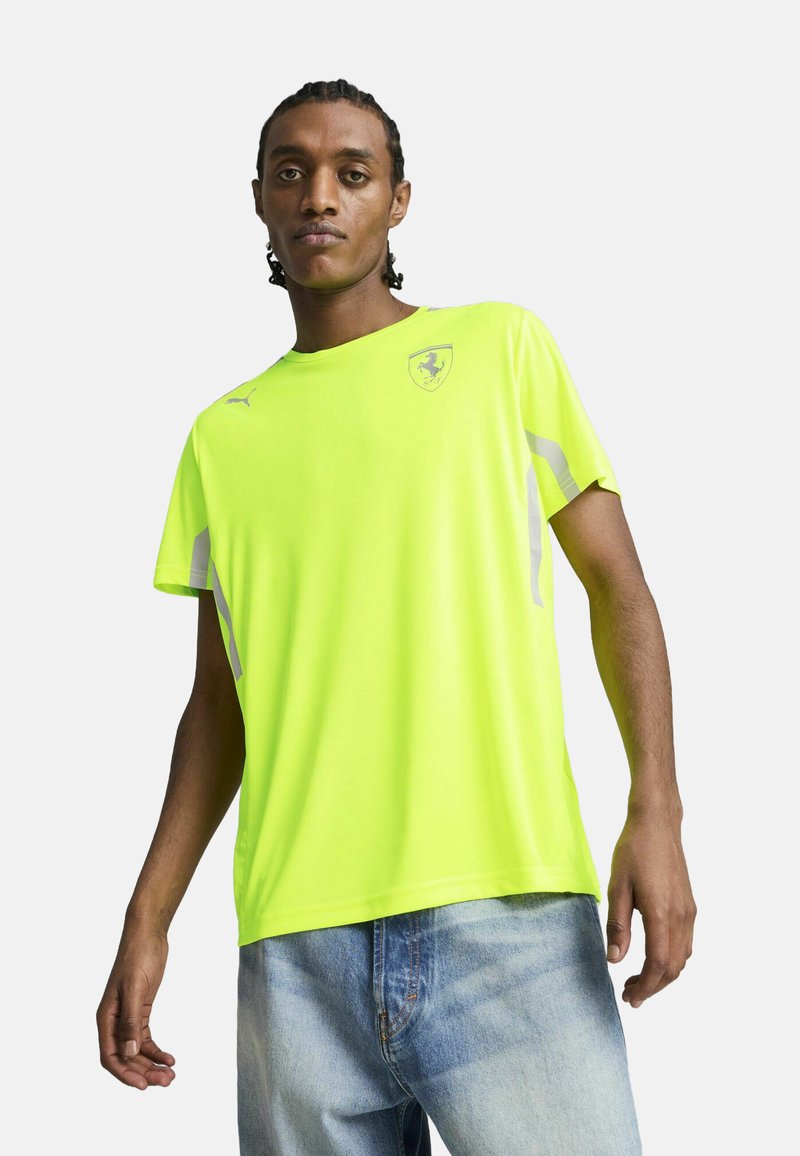 Neonowy żółty t-shirt sportowy z krótkimi rękawami, z małym logo Ferrari i szarymi akcentami po bokach. Wykonany z lekkiego materiału.