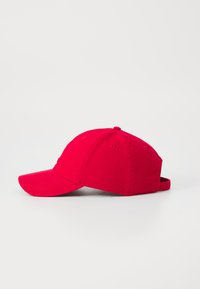 Casquette de baseball rouge avec une visière courbée, fabriquée en tissu au toucher lisse. Dispose d'une sangle ajustable à l'arrière et de trous de ventilation.