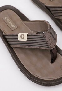 Sandalias de playa marrones con una correa texturizada, que presentan un acento gris, plantillas moldeadas y suela de goma para mayor tracción.