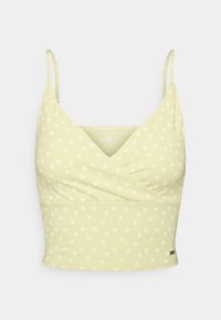 Light yellow cropped cami top with thin straps and small white floral print, featuring a wrap-front design.
