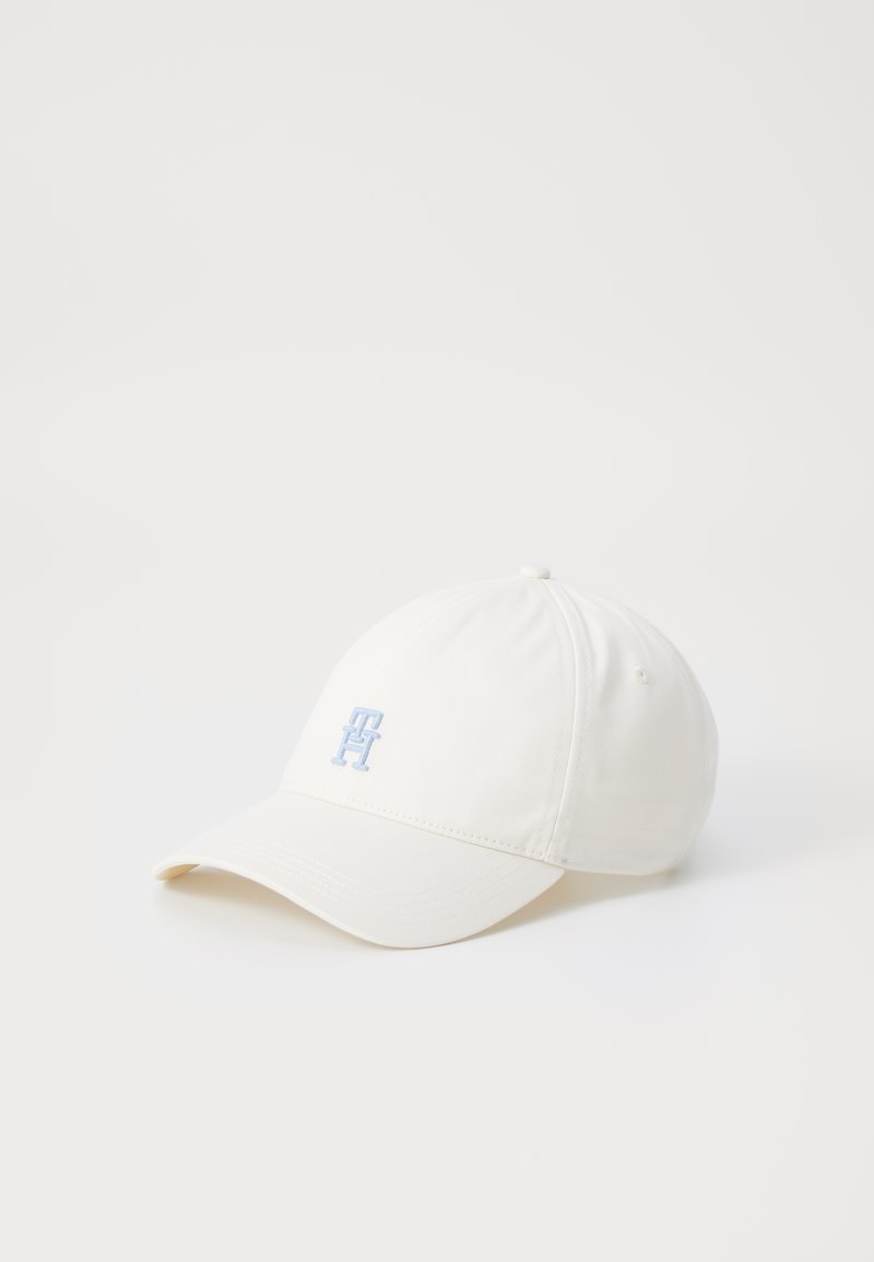 Cappellino da baseball bianco in tessuto, con visiera curva e un discreto logo blu ricamato sulla parte anteriore. Superficie testurizzata con dettagli di cucitura.