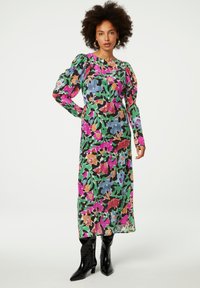 Maxi-jurk met een mix van levendige bloemenpatronen in roze, groen, blauw en zwart. Lange, gathered mouwen en een lichte, vloeiende stof.