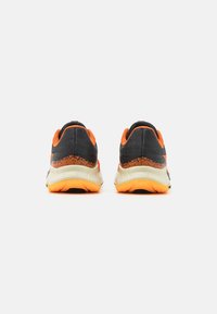 Zapatillas deportivas negras y naranjas con parte superior de malla transpirable, contrafuerte texturizado y una media suela y suela exterior ligeras en blanco.