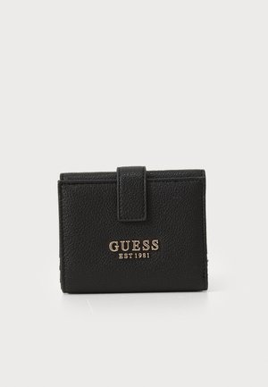 Carteira de pele preta com acabamento texturizado, fecho de botão e logótipo dourado "GUESS EST 1981" na parte da frente. Forma retangular compacta.