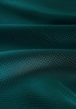 Teal kangas sujuva tekstuuriga, sisaldab peent kihi mustrit ja erinevaid toone, mis loovad materjalis sügavust.