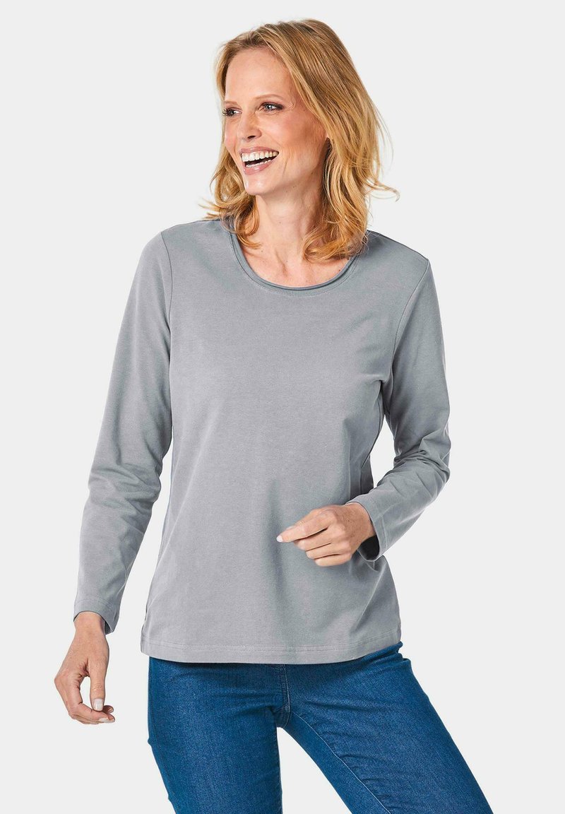 Graues Langarmshirt mit rundem Ausschnitt, aus weichem Stoff gefertigt, mit lässigem Schnitt und dezenten Steppdetails an den Schultern.