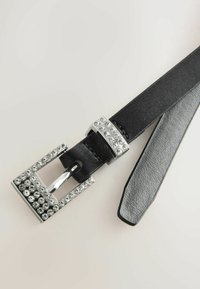 Čierny kožený opasok s obdĺžnikovou striebornou prackou zdobenou čírymi kryštálmi. Hladký povrch, elegantný dizajn a leštené kovanie.