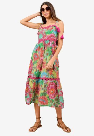 Maxi dress made of lightweight fabric, featuring a colorful floral pattern in pink, green, and blue, with ruffled straps and tassel accents.