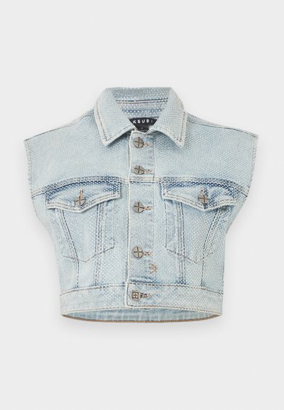 Αμάνικο κοντό γιλέκο από ανοιχτό γαλάζιο τζιν ύφασμα με ασημένιες τρουκς, κούμπωμα μπροστά με κουμπιά, δύο τσέπες με καπάκι στο στήθος και μυτερό γιακά.