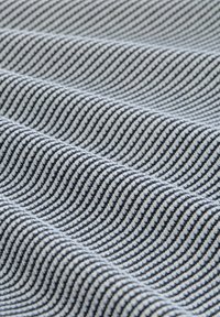 Tkanina o falistym wzorze, na przemian w ciemnoniebieskie i białe paski, tworząca teksturowany wygląd z widocznymi włóknami.