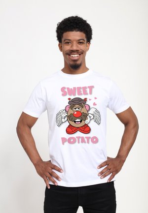 Hvid bomulds t-shirt med en tegneserie kartoffel karakter med vinger, røde sneakers, og teksten "SWEET POTATO" i pink.