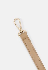 Beige leren band met een goudkleurige metalen clip. De band heeft nette stiksels en een gladde textuur, wat zorgt voor een minimalistisch ontwerp.