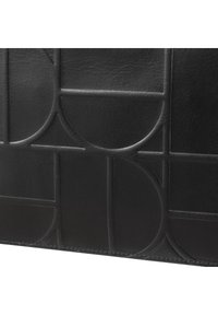 Borsa a spalla in pelle nera con un motivo geometrico in rilievo, texture liscia e cuciture ordinate lungo i bordi.