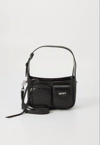 Black leather DKNY shoulder bag with adjustable strap, two front pockets—one zippered and one flap with logo—on plain background.