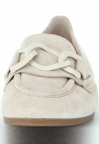 Beige suede slip-on shoe with a rounded toe and decorative off-white chain detail across the vamp. Rubber sole visible underneath.