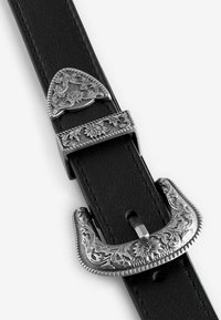 Ceinture en cuir noir avec une boucle en métal argenté ornée et des accents. Des composants détaillés triangulaires et rectangulaires rehaussent le design.