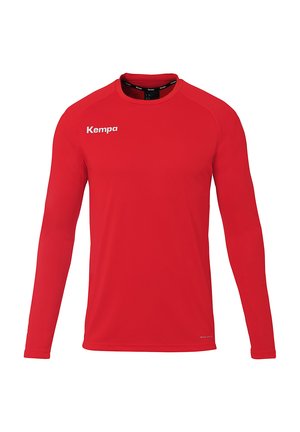 Rode sportshirt met lange mouwen, gemaakt van lichtgewicht, ademend materiaal, met een ronde halslijn en een wit "Kempa"-logo op de bovenste linkerzijde.