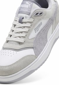 Zapatillas Puma que combinan ante gris y cuero blanco, con una caja de punta perforada y acentos grises. Diseño clásico de cordones.