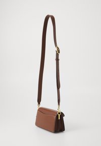 Sac à épaule en cuir marron avec une forme structurée, quincaillerie dorée, sangle réglable et détails de couture subtils.