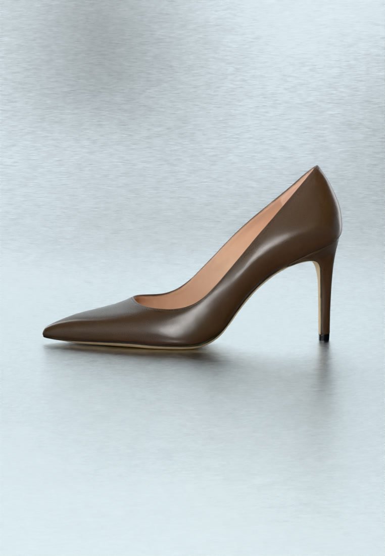Chaussure à talon haut en cuir marron à bout pointu avec un talon aiguilles fin sur une surface gris clair.