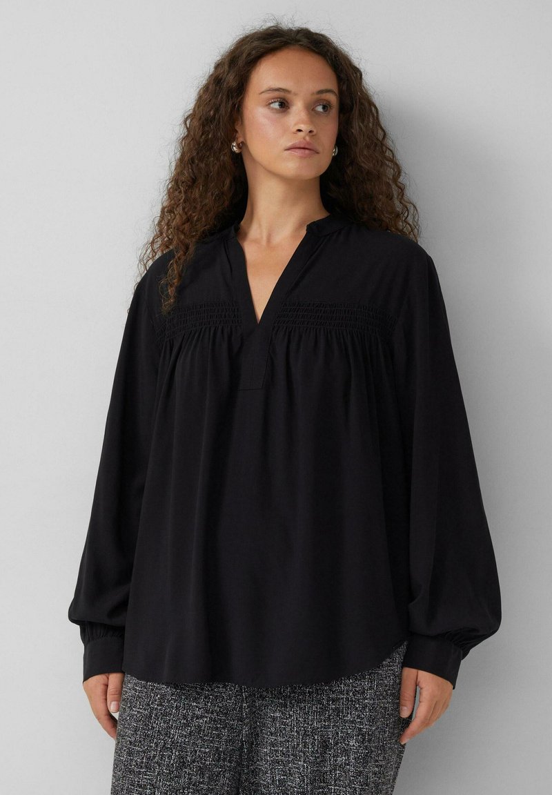 Zwarte blouse met lange mouwen en een V-hals, met gerimpelde details op de borst en een ontspannen pasvorm; gladde textuur en lichtgewicht stof.