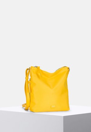 Sac à épaule en cuir jaune vif avec bandoulière ajustable et fermeture éclair, présenté sur un socle blanc sur un fond clair uni.