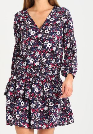 Floral dress with a deep V-neck, long sleeves, and smocked waist. Navy background with white and pink flowers, featuring a layered ruffle skirt.