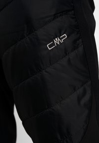 Pantaloni neri imbottiti con una texture trapuntata su un lato, tessuto liscio e logo CMP ricamato in bianco sulla coscia.