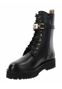 Stivale in pelle nera stringato con hardware dorato, cuciture a contrasto, suola robusta e chunky, e altezza alla caviglia per un supporto aggiuntivo.