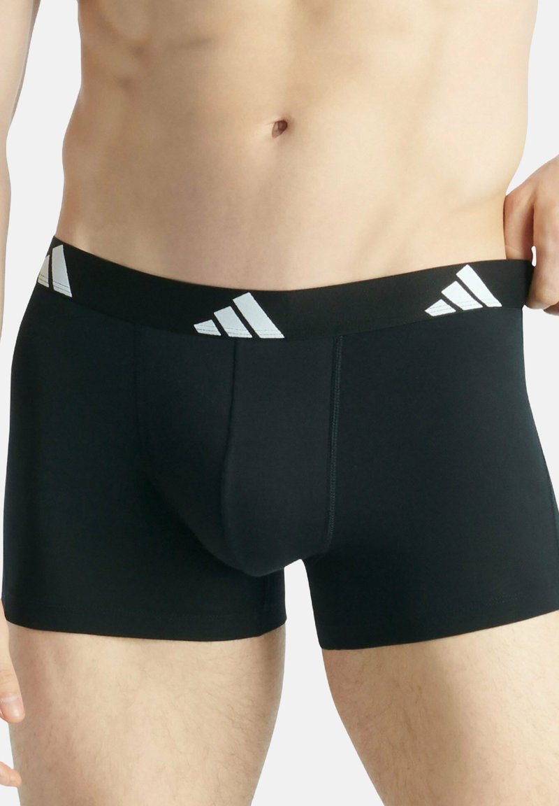 Czarne bokserki wykonane z elastycznego materiału z szerokim czarnym pasem w talii z białymi akcentami logo Adidas oraz smukłym, dopasowanym krojem.