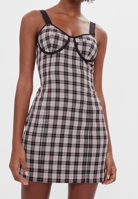 Svart rutigt klänning med röda och vita detaljer, figurnära passform, vadderad byst, justerbara axelband och kontrasterande kant. Slät tygtextur.