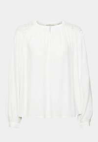 Camicia bianca a maniche lunghe con dettagli in pizzo sulle spalle, tessuto morbido, scollatura rotonda con pattina bottonata e polsini arruffati.