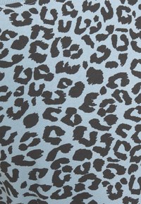 Ljusblå tyg med ett upprepat mönster av svart leopardtryck, med oregelbundna former och texturer typiska för djurtryck.