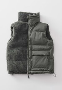 Gilet gris réversible avec une face en polaire et l'autre en tissu lisse, doté d'une fermeture éclair et d'une poche avant à rabat.