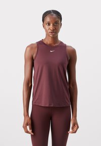 Bordeaux športni brezrokavnik s krožnim izrezom. Ima majhen bel Nike logotip na prsih. Gladek, raztegljiv material.