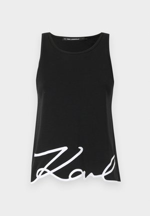 Black tank top made from smooth fabric featuring a wide neckline and a large white signature print on the lower front.