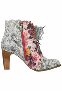 Botín de tobillo con estampado floral sobre un fondo blanco texturizado, cremallera rosa y tacón de madera marrón. Presenta adornos de encaje decorativos.