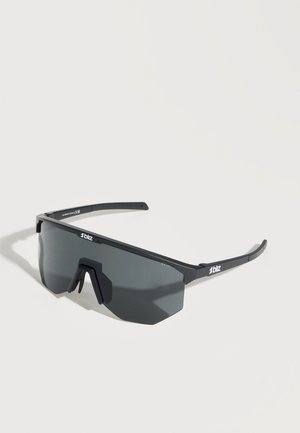 Μαύρα αθλητικά γυαλιά ηλίου με περιμετρικούς σκούρους γκρι φακούς και λεπτό ορθογώνιο σκελετό, εκτεθειμένα σε λευκή επιφάνεια.
