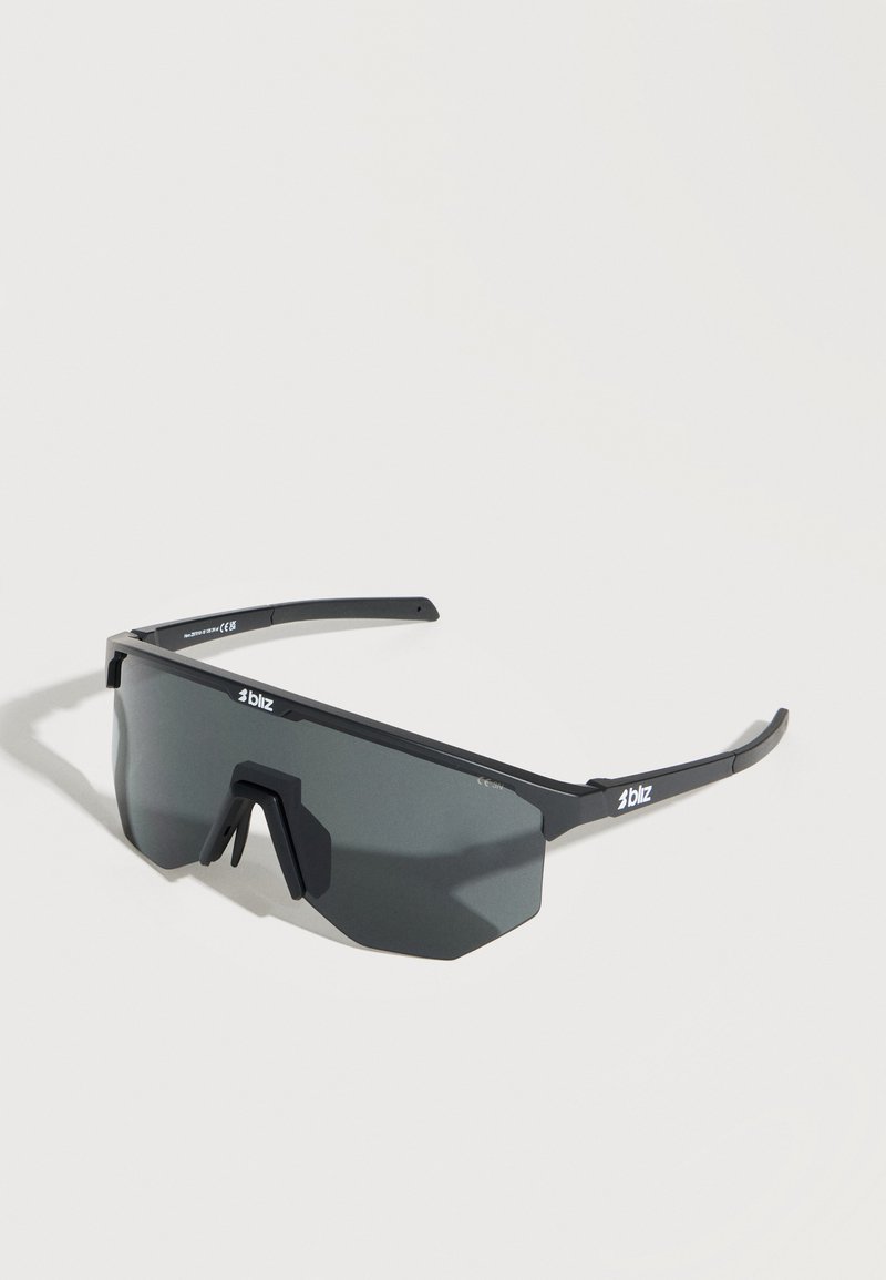 Μαύρα αθλητικά γυαλιά ηλίου με περιμετρικούς σκούρους γκρι φακούς και λεπτό ορθογώνιο σκελετό, εκτεθειμένα σε λευκή επιφάνεια.