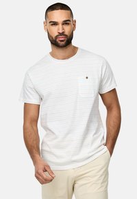 Weißes T-Shirt mit kurzen Ärmeln und dezenten horizontalen Streifen, Rundhalsausschnitt und einer Brusttasche mit einem kleinen braunen Knopfdetail.
