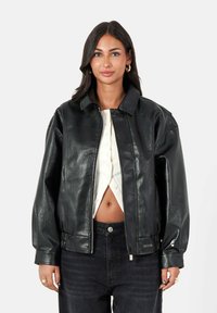 Zwarte leren bomberjack met een kraag, een gestructureerd oppervlak, een oversized pasvorm, ritssluiting en zijzakken.