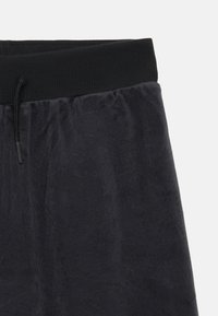 Donkergrijze sweatpants van een gekamde fleece stof, met een ribgebreide zwarte tailleband en een verstelbaar trekkoord.